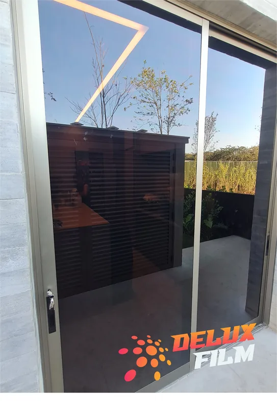 Película fumê de controle solar aplicada em porta de vidro