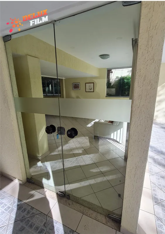 Adesivo jateado aplicado em vidro, padrão de faixas