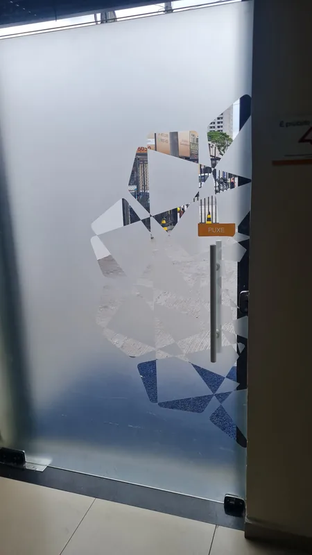 Adesivo jateado aplicado translúcido com logo em vidro