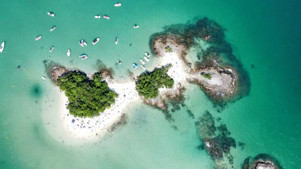 Vista aérea de ilha de Angra dos Reis cercada de lanchas e iates