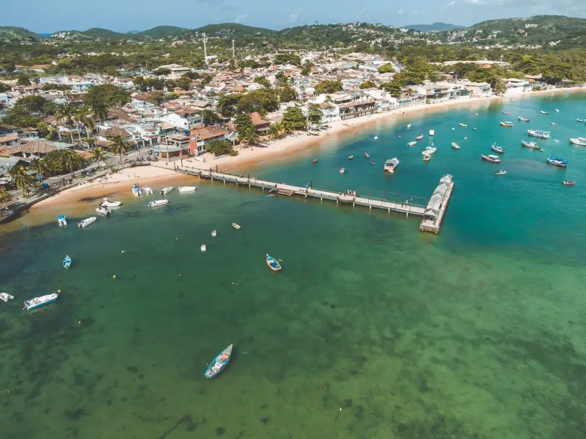 Vista aérea do píer e da orla de Armação dos Búzios com barcos fundeados