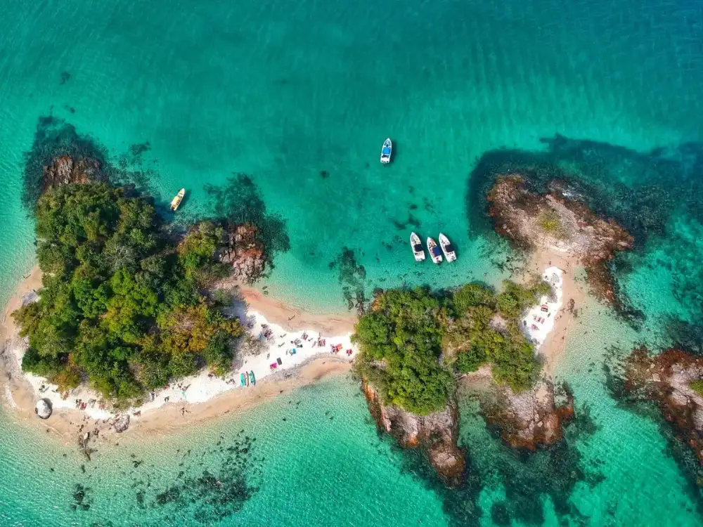 Vista aérea de ilhas com iates fundeados em água turquesa na região de Angra