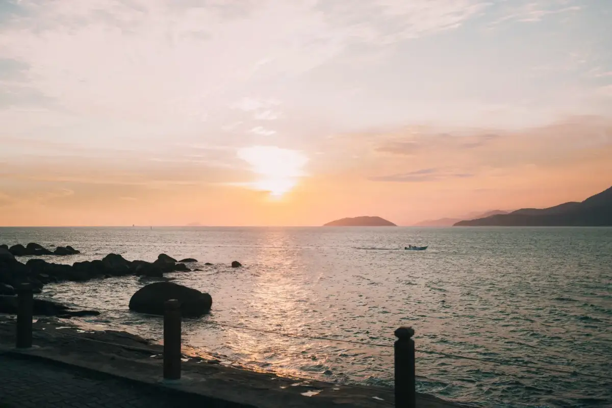 Pôr do sol no canal de Ilhabela com barco ao fundo