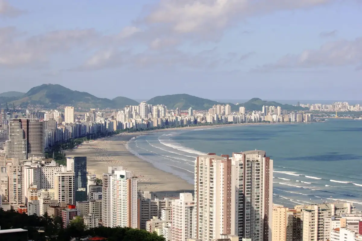 Vista panorâmica da orla de Santos com a curva da baía e os morros ao fundo